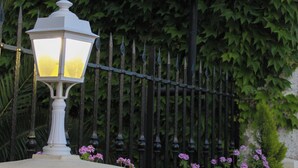A sign for 'HOTEL BEAU SITE' with a decorative lamp and a fence with greenery. - Hôtel Beau Site - Cap d'Antibes (Antibes)