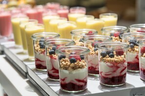 Eine Auswahl an bunten Parfaits in Glasgläsern, drapiert auf einer Tablett.