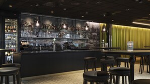 Un espace bar avec un comptoir, des tabourets et un présentoir à vin.