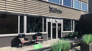 Un restaurant doté d’une terrasse, d’une enseigne au-dessus de l’entrée et offrant une vue sur la façade du bâtiment.