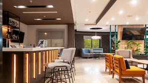 Una sala de estar moderna con una zona de bar, asientos y un ventanal con vistas.