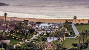 A resort with a pool area, palm trees, and a view of the ocean at sunset. - Four Seasons Hotel Alexandria at San Stefano (Alexandria)