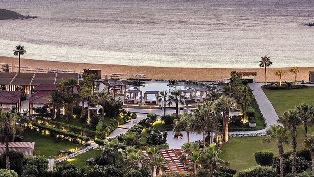 A resort with a pool area, palm trees, and a view of the ocean at sunset. - Four Seasons Hotel Alexandria at San Stefano (Alexandria)