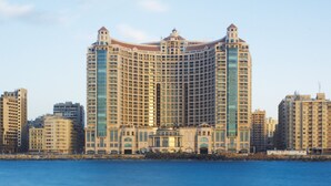 A large, multi-story hotel with a central atrium and a waterfront view. - Four Seasons Hotel Alexandria at San Stefano (Alexandria)