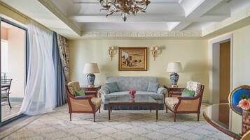 A well-furnished living room with a sofa, two armchairs, a coffee table, and a chandelier.