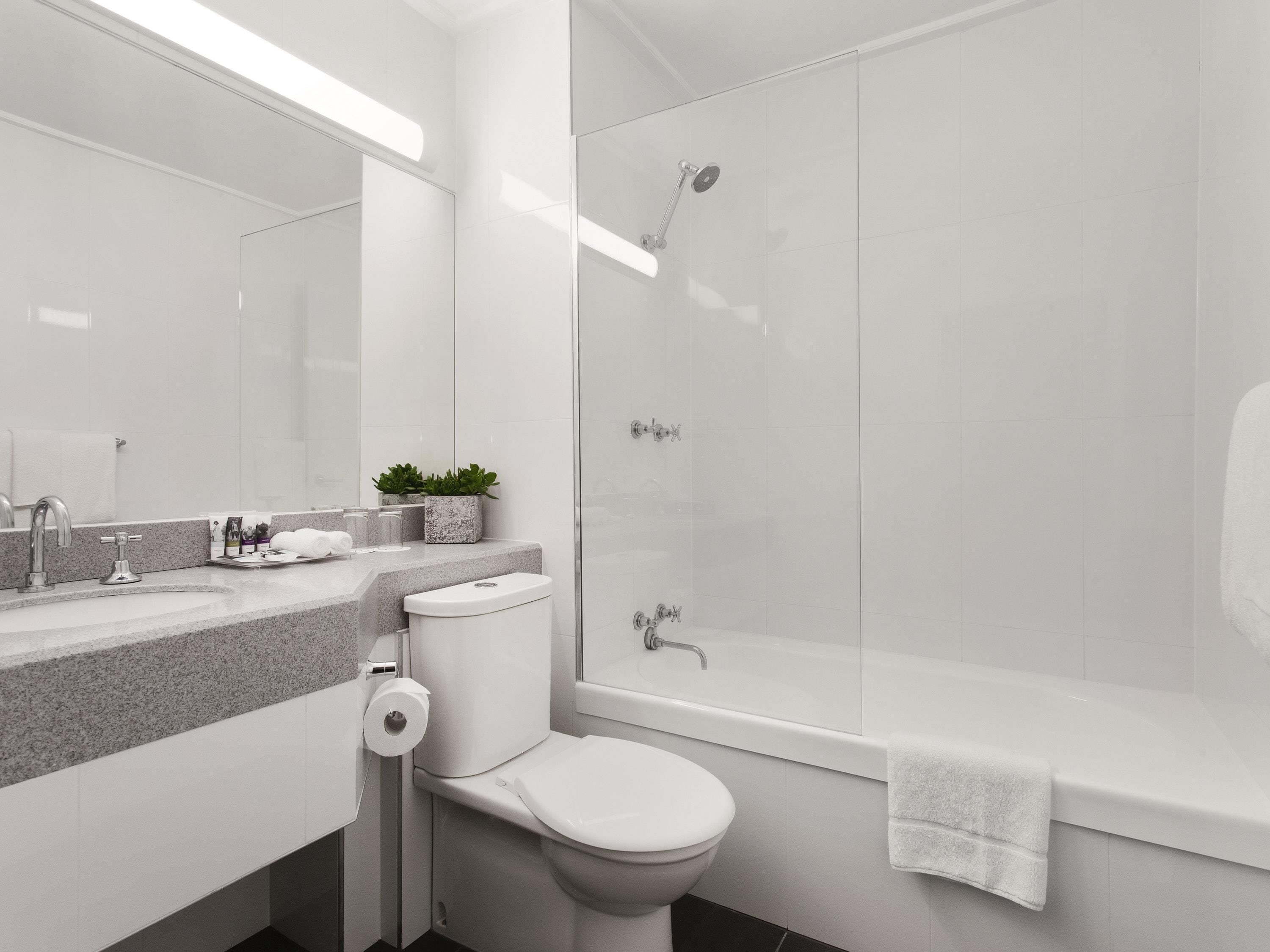 Une salle de bain moderne équipée de toilettes, d’un lavabo et d’une douche.