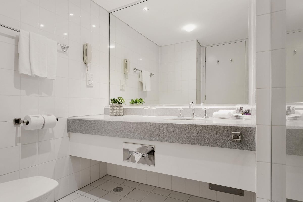 A modern bathroom with a toilet, sink, and shower.