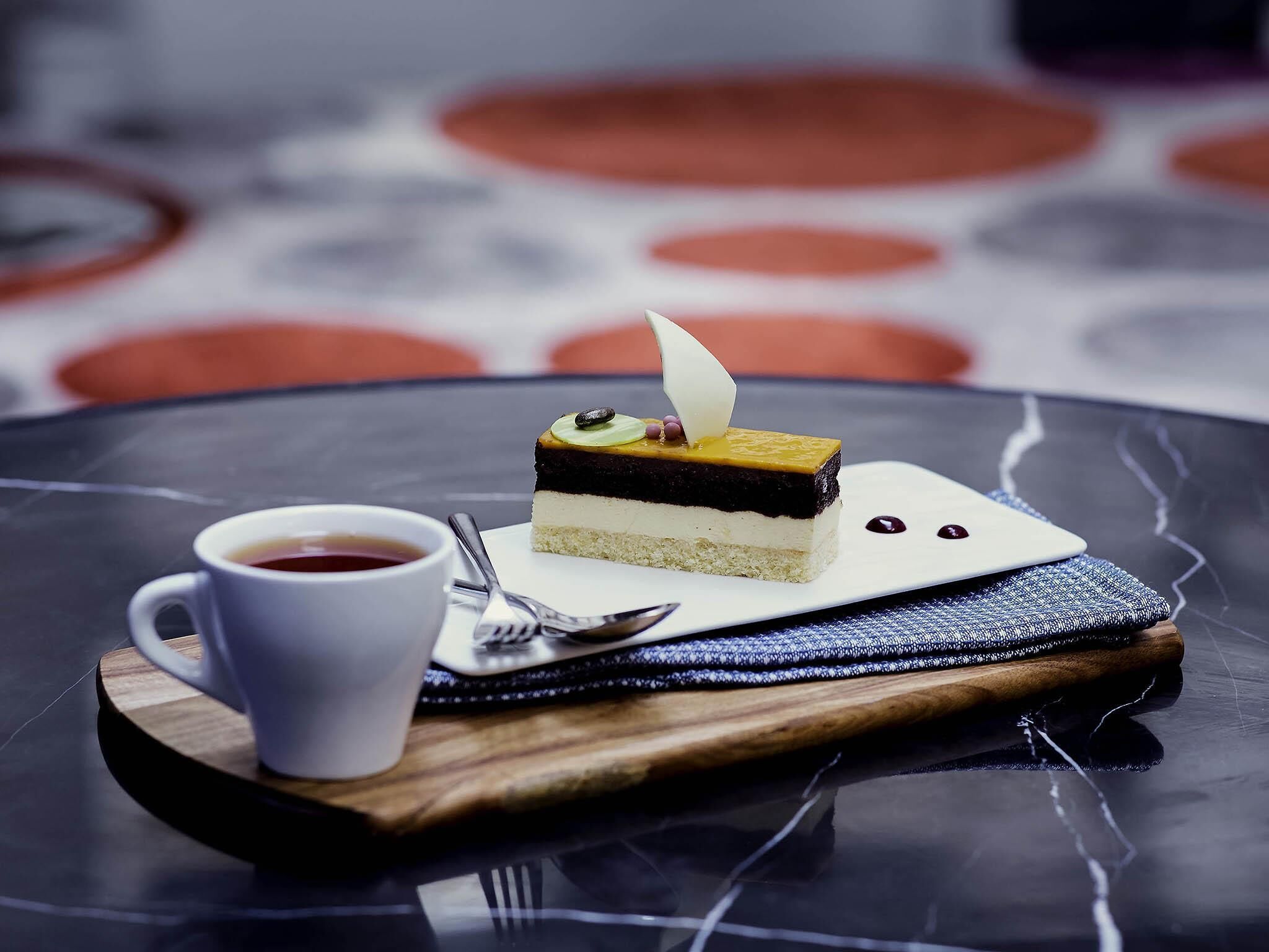 Un postre en un plato con una taza y una cuchara cerca.