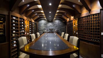 Enjoy wine tastings and comfortable seating in this sophisticated wine cellar with a long, polished table.