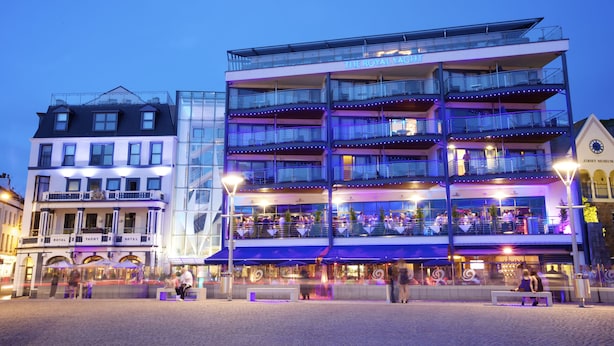 Un hotel de varios pisos con balcones y zonas de estar al aire libre.