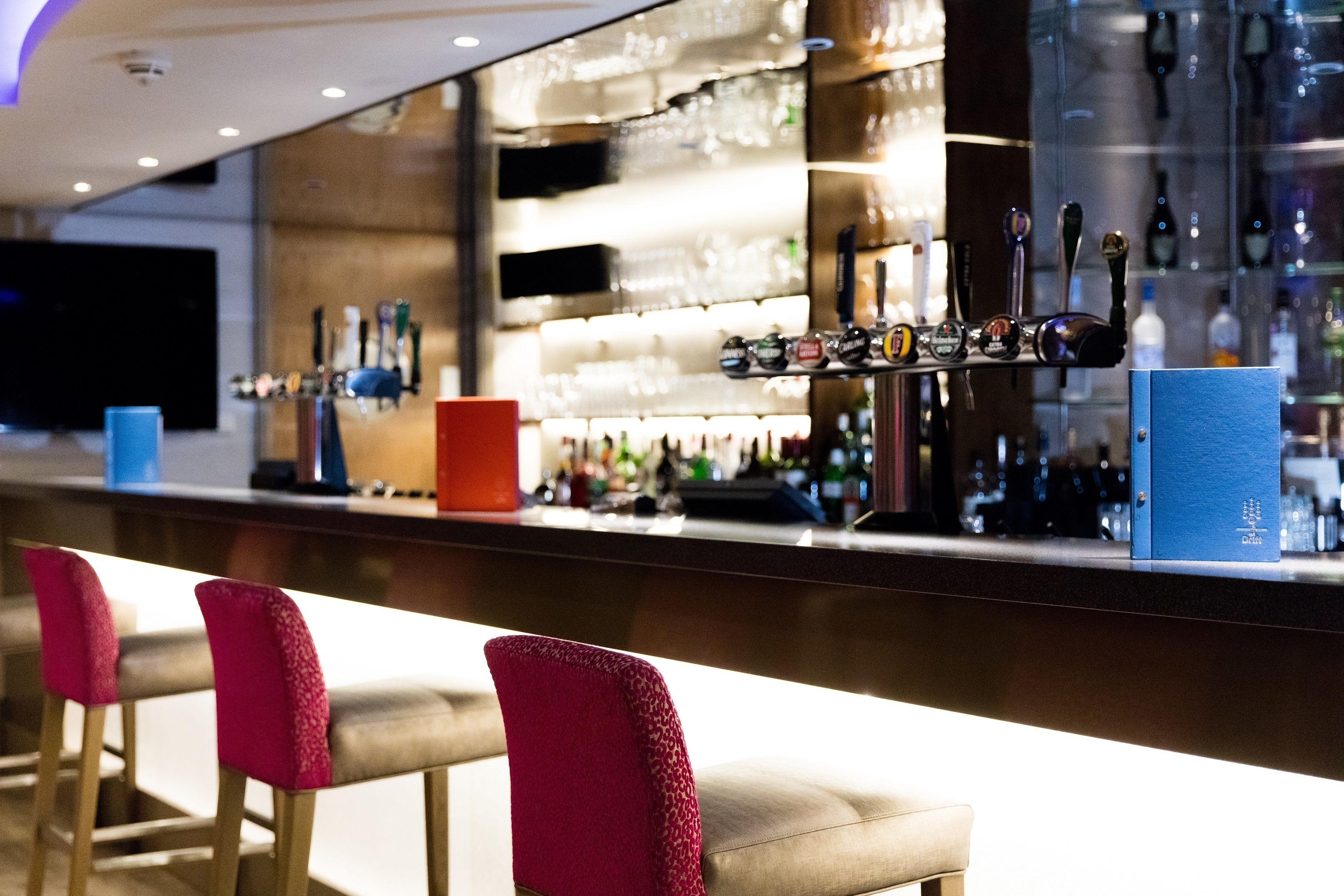 Un espace bar doté de plusieurs robinets, d’un comptoir et de tabourets de bar.