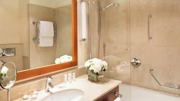Un baño moderno con un espejo grande, un lavabo, ducha y bañera.