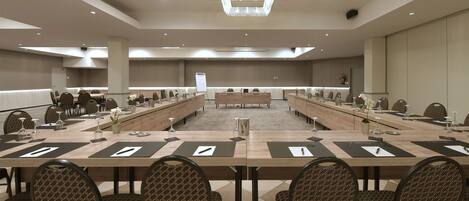Ein Konferenzraum mit langen Tischen, Stühlen und Namensschildern.