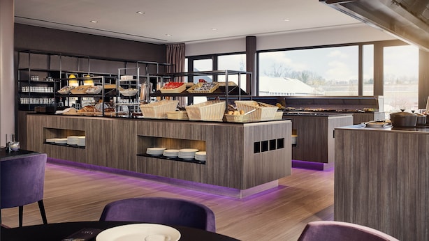 A modern kitchen with a central island, built-in shelves, and a view of the outdoors. - Van Der Valk Hotel Charleroi Airport (Charleroi)