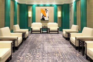 A conference room with a patterned carpet, white chairs, and a central table. - Yinlong Hotel (Xining)