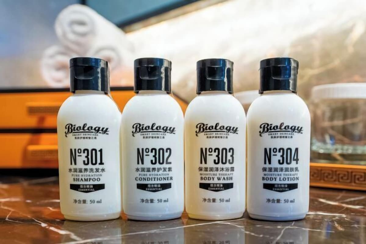 Cuatro botellas de productos para el cuidado de la piel Biolgy sobre una superficie de mármol.