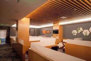 Habitació d'hotel amb sostre de fusta, un llit, escriptori i televisió penjada a la paret.
