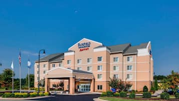 Experience the welcoming entrance of this hotel, featuring a covered walkway and prominent American flags.