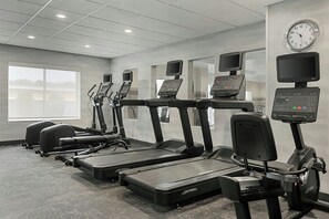 Un gimnasio equipado con cintas de correr, elípticas y máquinas de pesas.