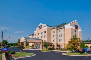 A multi-story hotel with a beige facade, a covered entrance, and a parking lot. - Fairfield Inn & Suites by Marriott South Hill (La Crosse)