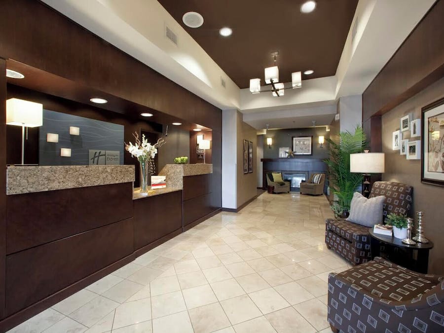 A hotel lobby with a reception desk, seating area, and a fireplace.