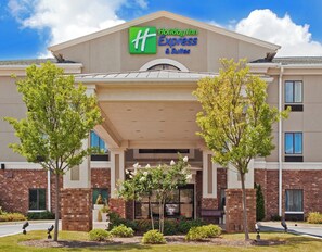 Edifício Holiday Inn Express & Suites com telhado plano, fachada de tijolos e uma placa sobre a entrada.