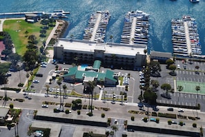 An aerial view of a marina with multiple docks and boats, a parking lot, and a building with a green roof. - Hampton Inn Channel Islands Harbor/Oxnard (Oxnard)