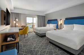 A hotel room with two beds, a desk, a chair, a TV, and a view of the marina. - Hampton Inn Channel Islands Harbor/Oxnard (Oxnard)