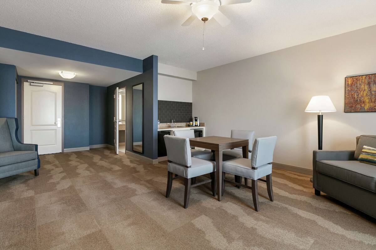 Un salon comprenant un coin repas, un canapé, une lampe et un ventilateur de plafond.