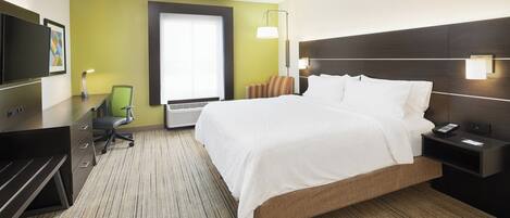 A hotel room with a bed, desk, chair, and a television.