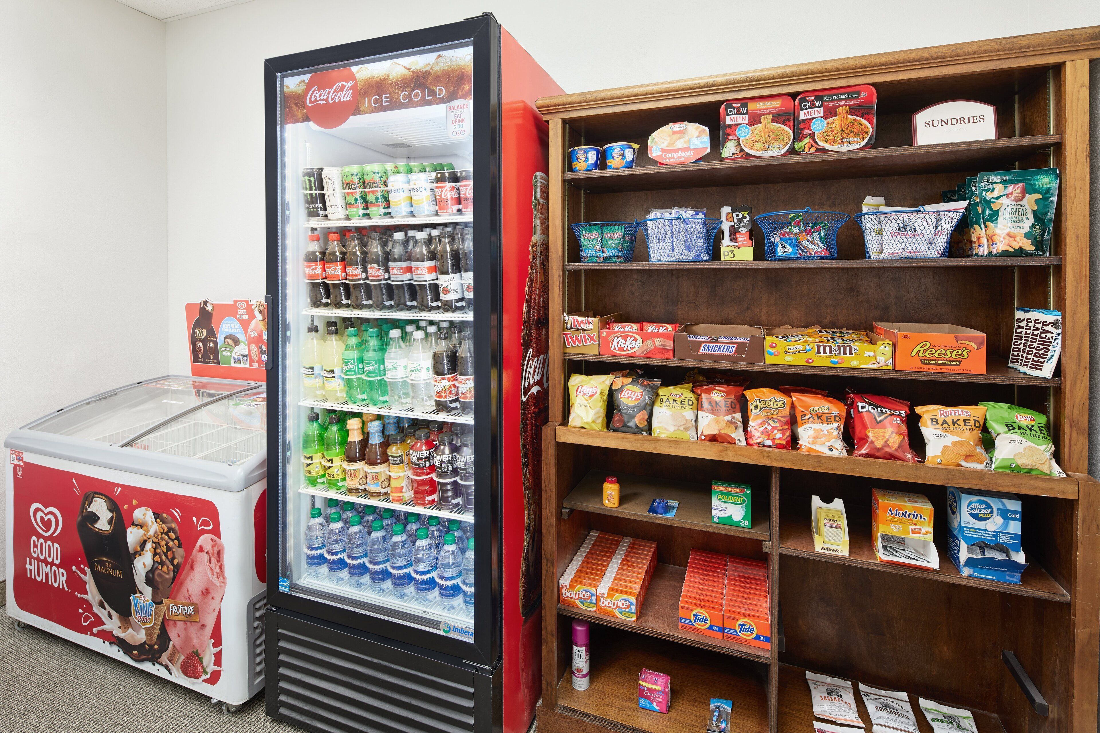 A vending machine with a variety of snacks and drinks, and a shelf stocked with packaged goods.