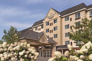 A Country Inn & Suites building with a beige facade, multiple windows, and a covered entrance.