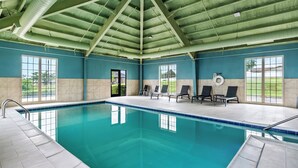 An indoor swimming pool with clear blue water, surrounded by lounge chairs and a tiled floor. - Holiday Inn Express Ada by IHG (Ada)