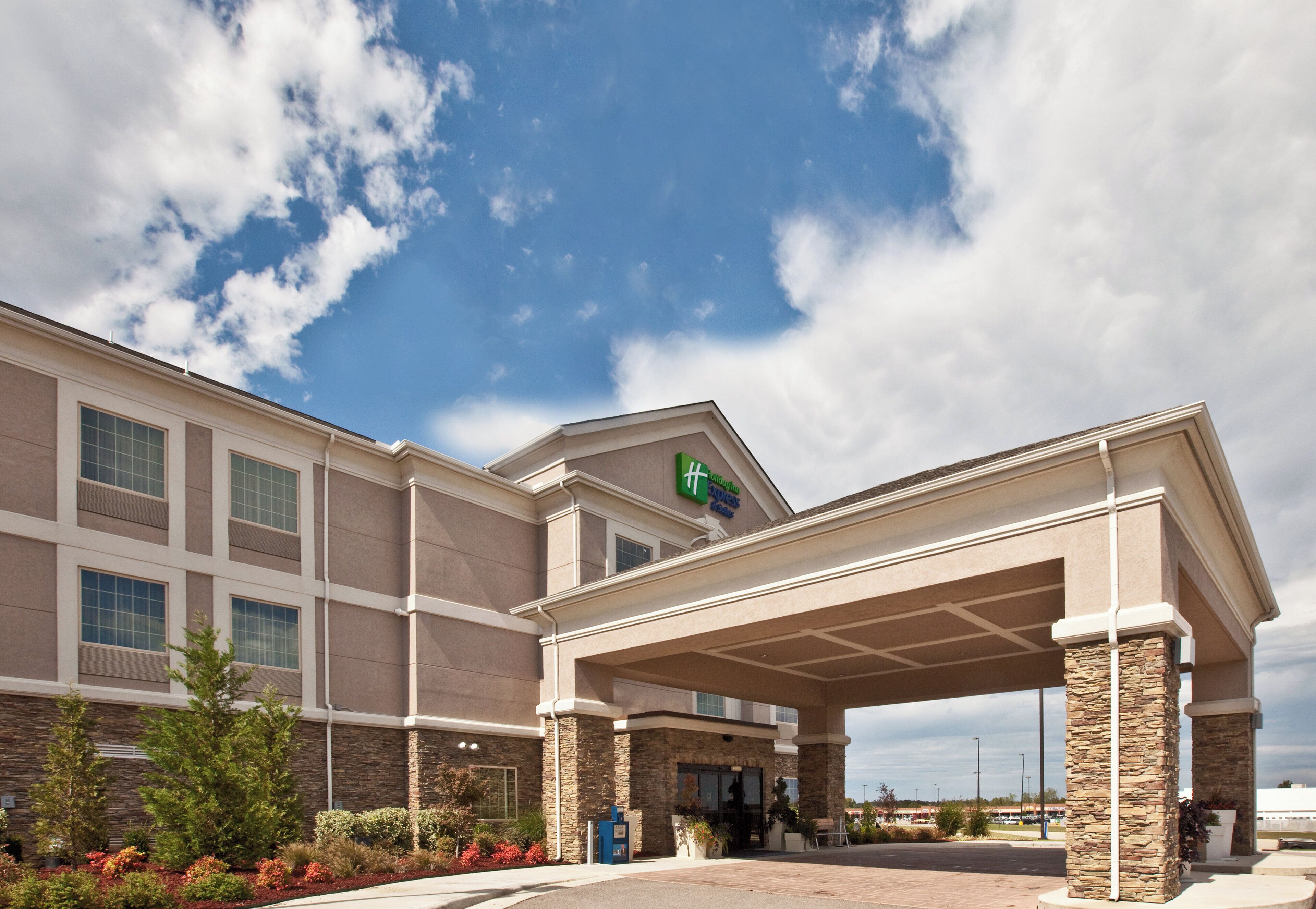 A hotel with a covered entrance, stone facade, and a Holiday Inn Express sign.