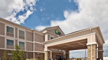 A hotel with a covered entrance, stone facade, and a Holiday Inn Express sign.