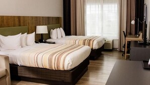 A hotel room with two beds, a desk, a chair, a lamp, and a window with curtains. - Country Inn & Suites by Radisson, Winchester, VA (Winchester)
