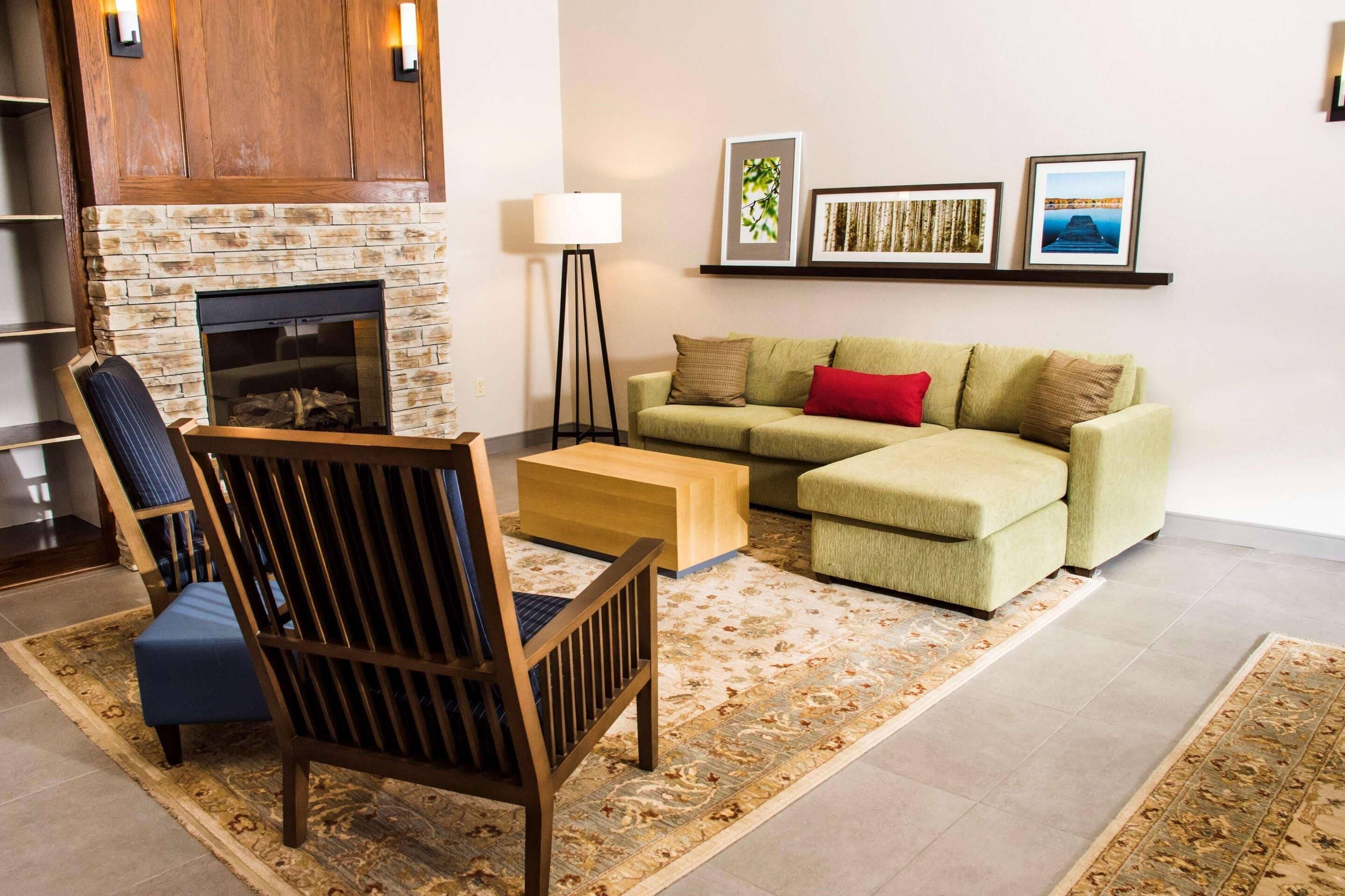 A living room with a fireplace, a sofa, a chair, a floor lamp, and a coffee table.