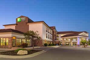 A Holiday Inn Express hotel with a brick facade, large windows, and a well-lit entrance. - Holiday Inn Express Hotel & Stes Salt Lake City-Airport East by IHG (Salt Lake City)