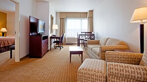 A hotel room with a bed, a TV, a desk, a chair, a sofa, and a lamp. - Holiday Inn Madison at The American Center by IHG (Madison)