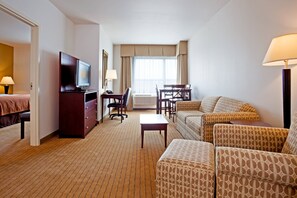 A hotel room with a bed, a TV, a desk, a chair, a sofa, and a lamp. - Holiday Inn Madison at The American Center by IHG (Madison)