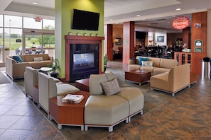 A hotel lobby with seating areas, a fireplace, a bar, and a sign indicating a non-smoking area. - Holiday Inn Madison at The American Center by IHG (Madison)