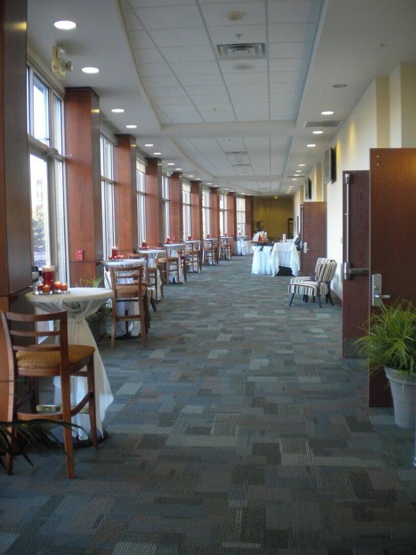 A long corridor with tables and chairs, suggesting a dining area or lounge.