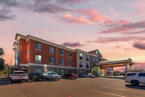 A multi-story hotel with a parking lot, featuring a prominent sign and a well-lit entrance. - Holiday Inn Express Hotel & Suites Fairfield - North by IHG (Fairfield)