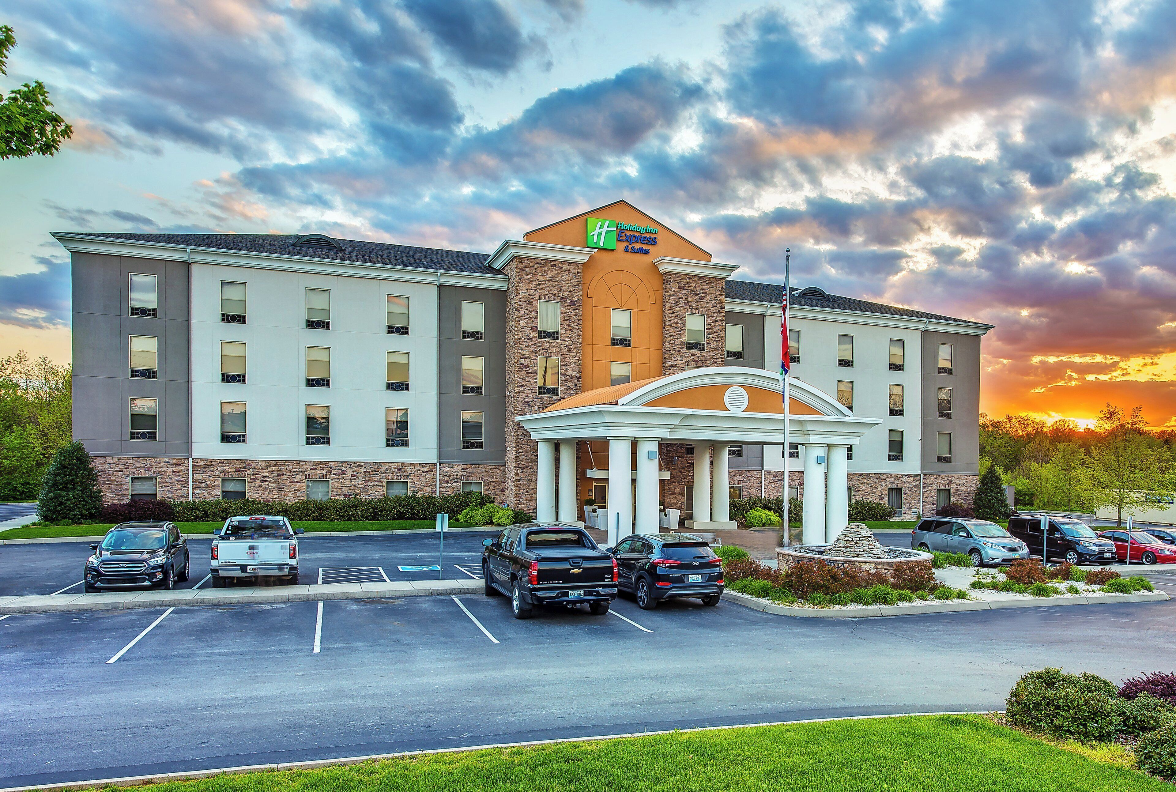 Un hotel Holiday Inn Express con un estacionamiento y una entrada con acceso por una vía.