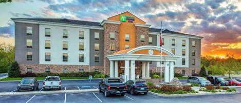 Un hotel Holiday Inn Express con un estacionamiento y una entrada con acceso por una vía.