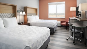 A hotel room with two beds, a desk, a chair, a TV, and a window with a view. - Holiday Inn Odessa by IHG (Odessa)