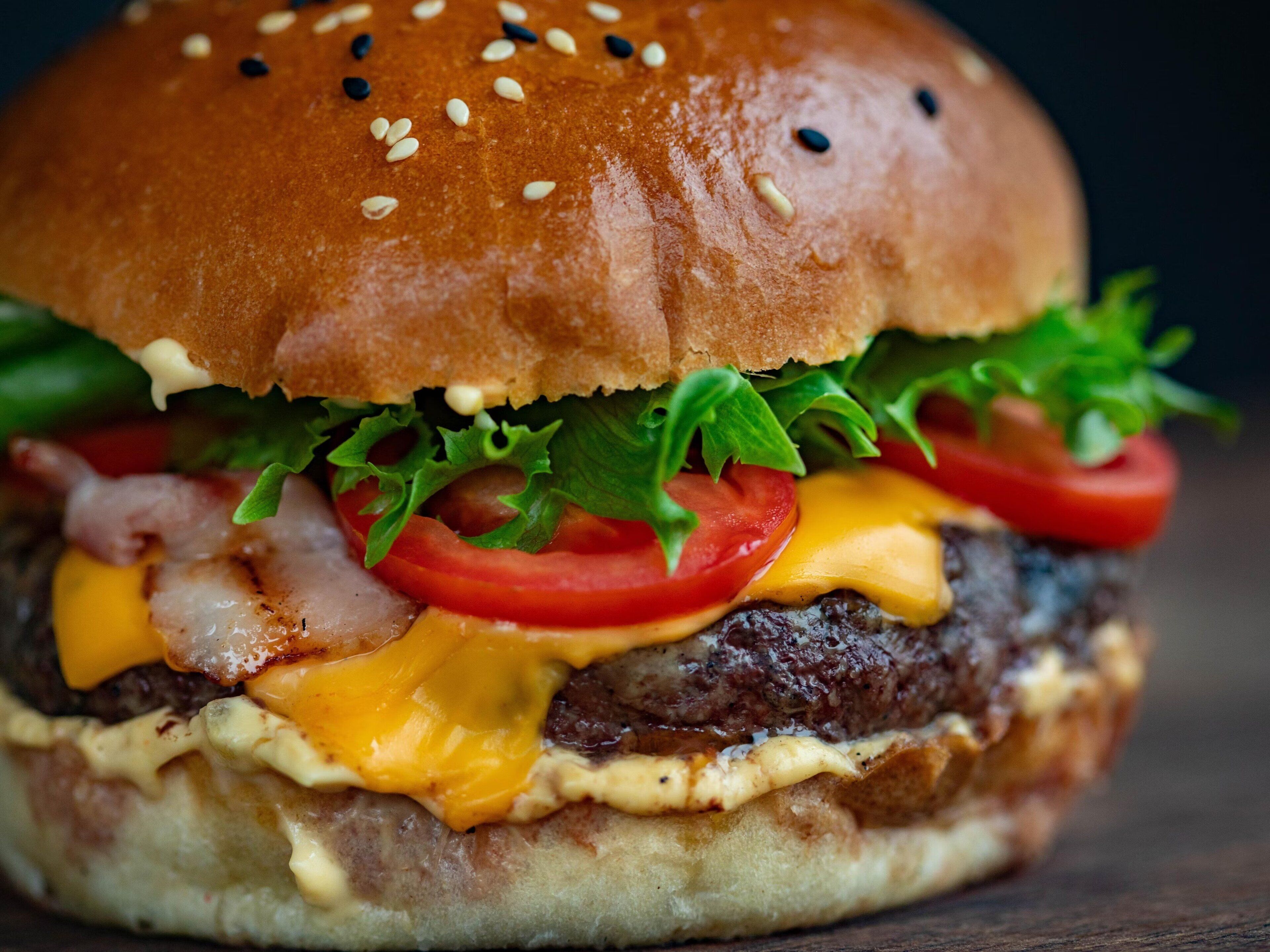 A close-up of a burger with sesame seeds on the bun.