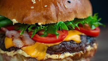 A close-up of a burger with sesame seeds on the bun.