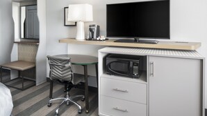 A hotel room with a bed, a desk with a computer, a chair, a TV, a coffee maker, and a microwave. - Holiday Inn Odessa by IHG (Odessa)