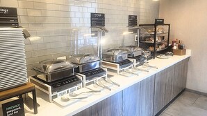 A buffet area with various food stations, including a hot foods section and a bakery.